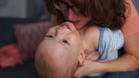 Mother holding her son doing handstand in her bedroom. Mother and son have fun Stock Footage 120989814