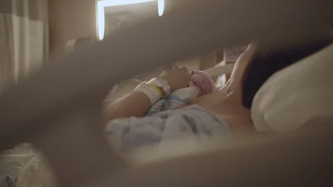 Mother Holding Newborn Baby Looking Through Hospital Bed HD|4K Stock Footage 128923177