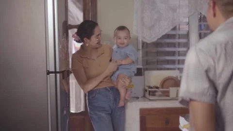 Mother holding son while father washes dishes Vidéo 341891994