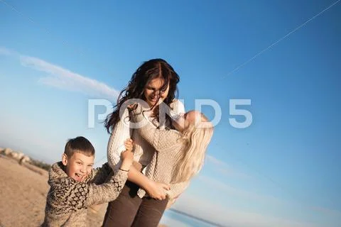 Mother Holds On A Hands His Little Daughter And Son Holds To Their