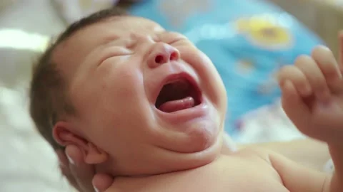 A mother holds a newborn screaming child in her arms. Crying newborn baby in the Stock Footage