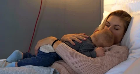 Mother hugging her sleeping child in bedroom Video stock 112962103
