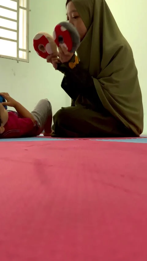 A mother interacting with a child on a floor mat Stock Footage 344918835