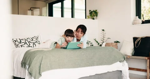 Mother, kid and bonding with tablet on bed for weekend break, conversation or Stock Footage 335509501