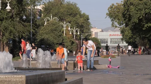 Mother with kids playing on Zhibek Zoly pedestrian street,Almaty,Kazakhstan Stock Footage