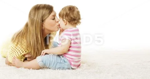 Mother Kiss Her Daughter, Infant Kid Kissing Mom, Happy Baby Sitting on Wite Stock Photos