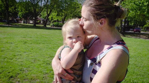Mother kissing her daughter in park | Stock Video 