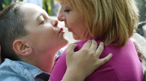 Mother kissing her son in the park, slow... | Stock Video 