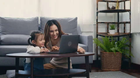 Mother with laptop computer teaching her kid to learn or study online Video stock 150485926