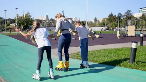 Mother Learns Rollerblading with Daughters in Sunny Park Stock Footage 285241451