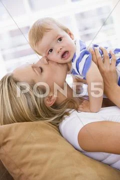 Mother in living room kissing baby Stock-Fotos