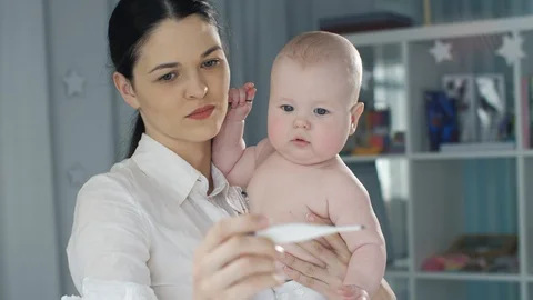 Mother looking at the thermometer Stock Footage 87837031