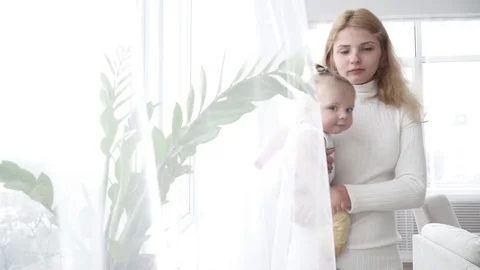 Mother looking at the window with her small baby boy Stock Footage 73633951