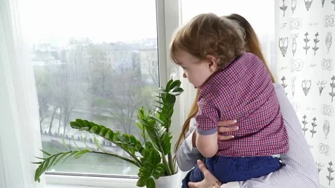 Mother looking to the window with her small baby son slow motion Stock Footage 74644501