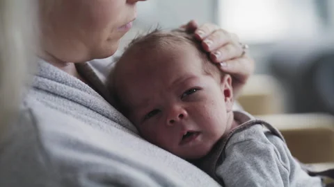 Mother lovingly hugs her newborn during a peaceful moment at home Stock Footage 310250412