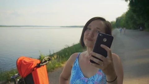 Mother makes selfie in the background of a stroller Stock Footage 92157093