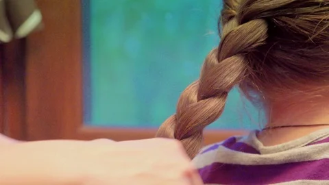 Mother is making of braid on little daughters head Stock-Footage 89573186