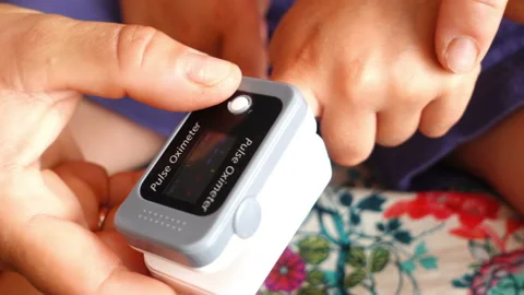 Mother measuring oxygen saturation with pulse oximeter of her child. Stock Footage 207224264