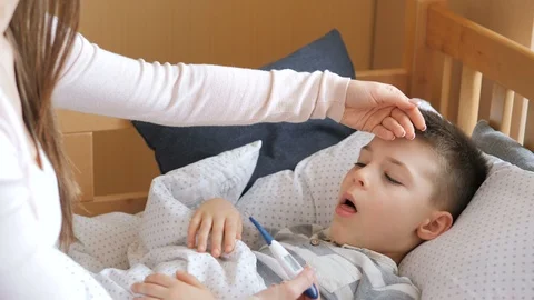Mother measuring temperature of her ill kid. Sick child with high fever lying at Video stock 126799147