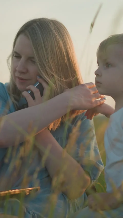 Mother Multi-tasking in Field with Two Sons Видео 308229733