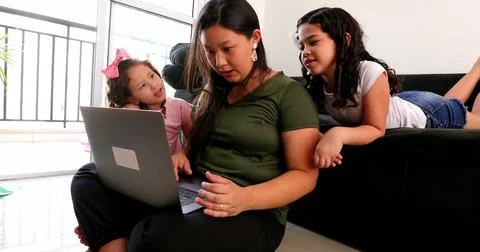 Mother parenting and working at the same time, mom multi-tasking between work Stock Photos