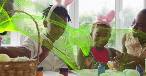 Mother passing paint jars sparking family Easter egg painting at table with Stock Footage 320089405