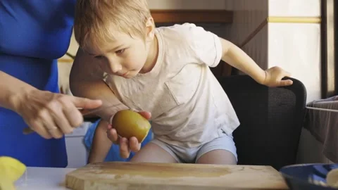 Mother peeling potato with crying son Stock Footage 319164957