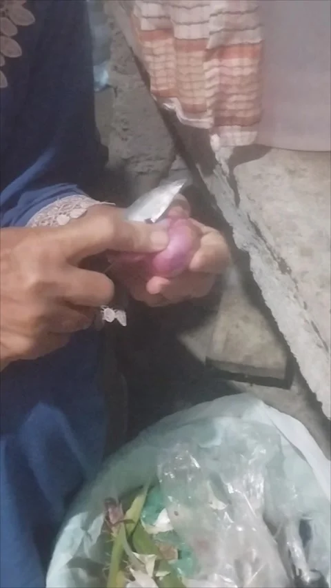 Mother peels red onions using a knife Stock Footage 290984964