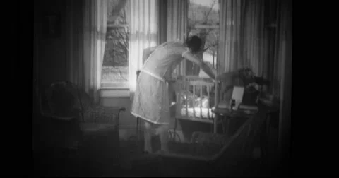 Mother picking baby up from cot Stock Footage 43447741