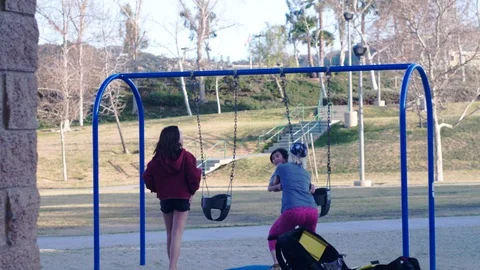 Mother picks up spin spin in circle her son play on swing slow motion 2 Stock Footage 124950791