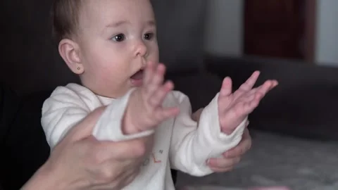 Mother playing with 6 month old daughter clapping her hands Stock Footage 276427739