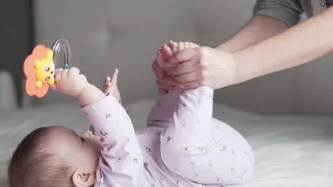 Mother playing and doing exercise  with her little baby in bed Stock Footage 275746832
