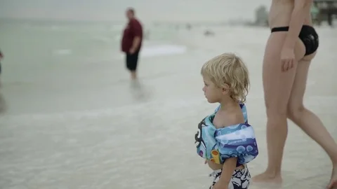 Mother playing with her young son in the beach waters 4k Stock Footage 81492123