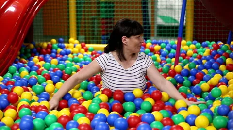 Mother is playing in pool with a balls Stock Footage 61411913