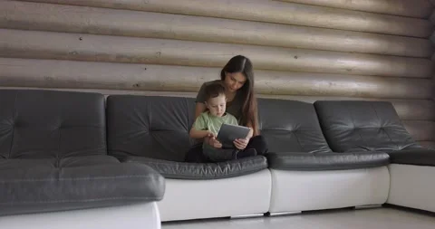 Mother plays with her child using an app over the Internet, hugging him Stock Footage 197441619