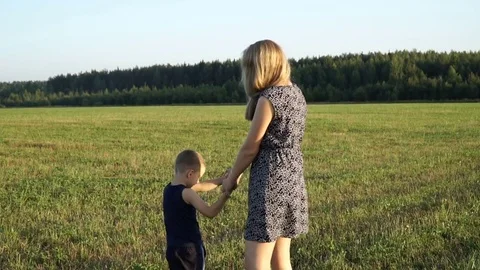 Mother plays with son at field at sunset. Slow mo Stock Footage 80343384