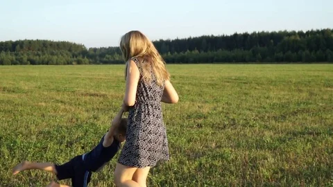Mother plays with son at field at sunset. Slow mo Video stock 80343487