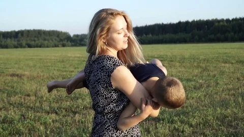 Mother plays with son at field at sunset. Slow mo Video stock 80343626