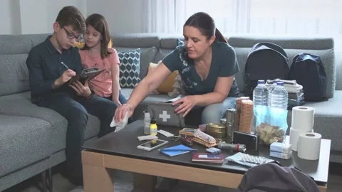 Mother preparing emergency backpack with her children Stock Footage 172419937