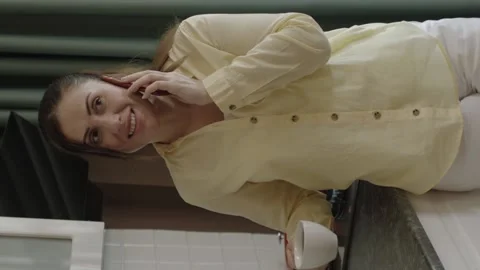 Mother preparing food in kitchen, talking on cell phone while drinking coffee. Stock Footage 204713272