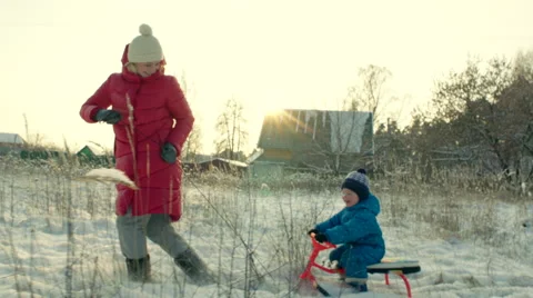 Mother Pulling Sledge with her Smiling Son in Winter Stock Footage 60387113