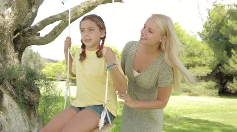 Mother pushing daughter on the swing Stock Footage