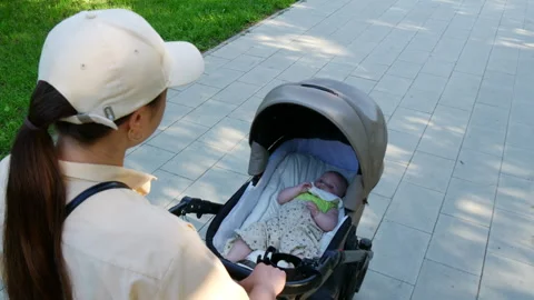 Mother is pushing a stroller with her child. Stock Footage 337536439