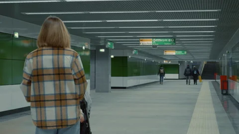 Mother pushing stroller in subway corridor Video stock 302472460