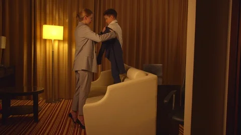 Mother put on a jacket on little boy in hotel Stock Footage 121939972