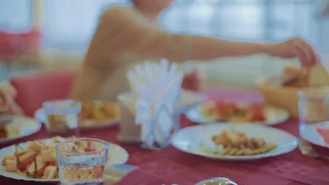Mother puts bread on her daughter's plate,young girl chop the meat with a fork Stock Footage 129520321