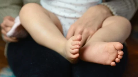 Mother puts socks on one-year-old's child feet. Close up 스톡 동영상 127752963