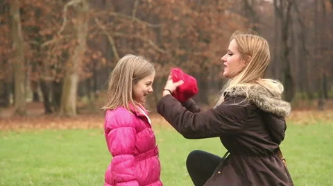Mother putting cap on daughter's head and kissing her in forehead Stock Footage 59554170
