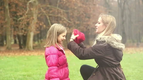 Mother putting cap on daughter's head and kissing her in forehead Stock Footage 59554171