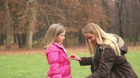 Mother putting cap on daughter's head and kissing her in forehead Stock Footage 59554178